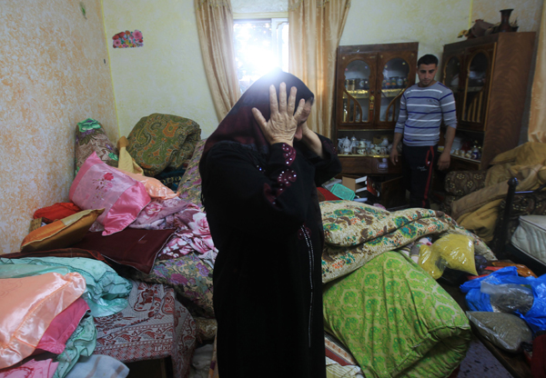 A Palestinian woman reacts as she stands in an overturned room after Israeli forces searched the house during an operation to arrest wanted Palestinians in the northern West Bank village of Deir Al Hatab, east of Nablus, early on Monday (AFP photo)