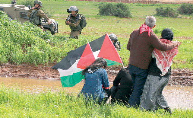 Israeli forces take aim as Palestinian demonstrators take part in a protest against the proposed annexation of the Jordan Valley, in the village of Tammun, east of the West Bank village of Tubas, near the Jordan Valley, on Saturday (AFP photo)