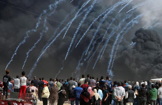 Tear gas canisters are fired by Israeli troops at Palestinian demonstrators during clashes at the Israel-Gaza border, April 27, 2018 (Reuters photo)
