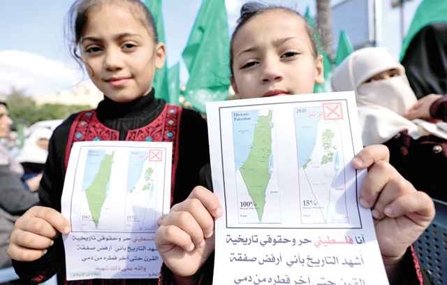 Young Palestinian girls hold petitions with a map of British mandate Palestine (left) and a current map of the Palestinian territories without Israeli-annexed areas and settlements, as they take part in a demonstration against the US plan for Middle East, in Gaza City on Wednesday (AFP photo)