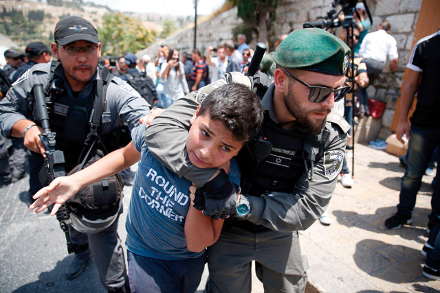 Israeli soldiers detain a Palestinian youth during a demonstration outside the Lions Gate, a main entrance to Al Aqsa Mosque compound, due to newly implemented measures by Israeli authorities which include metal detectors and cameras, in Jerusalem’s Old City on Monday (AFP photo)
