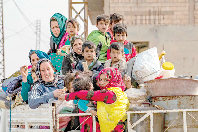 Syrians flee with their belongings the countryside of the north-eastern Syrian town of Ras Al Ain on the Turkish border, towards the west to the town of Tal Tamr on Saturday (AFP photo)