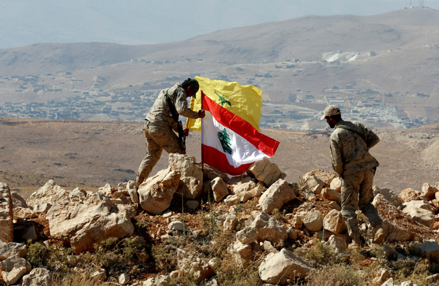 Hizbollah fighters put Lebanese and Hizbollah flags at Juroud Arsal, Syria-Lebanon border, on Tuesday (Reuters photo)