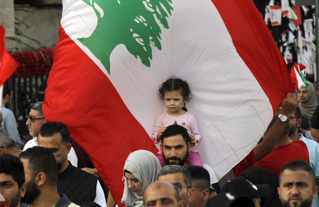 Lebanese anti-government protesters wave national flags as they take part in an anti-govenment demonstration in the centre of Sidon, the capital of south Lebanon, on Sunday (AFP photo)