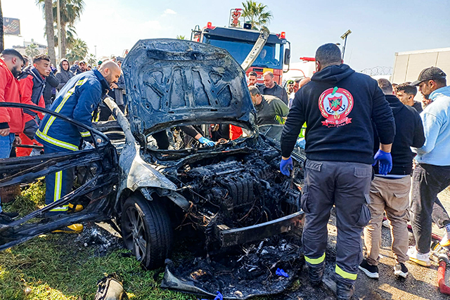Lebanese army, security forces, and civil defence first responders inspect the remains of a destroyed vehicle that was reportedly hit by an Israeli strike in Lebanon's southern city of Sidon on February 17, 2025 (AFP photo)