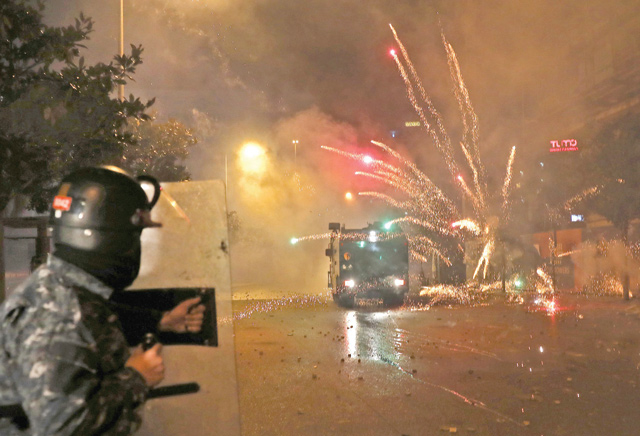 Supporters of Lebanon's Shiite Hizbollah and Amal groups hurl fireworks at security forces late on Tuesday in central Beirut (AFP photo)