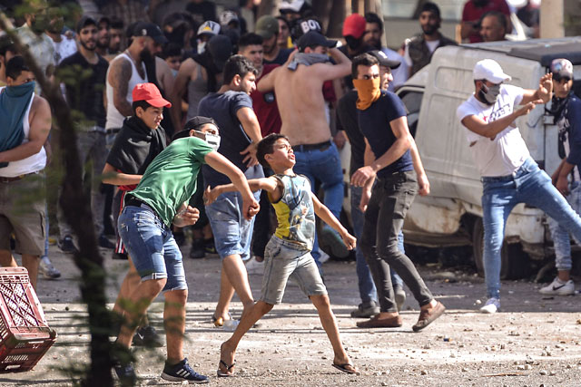 Lebanese anti-government protesters hurl rocks at soldiers amid clashes in the Bab Al Tabbaneh neighbourhood in the northern port city of Tripoli, on Saturday (AFP photo)