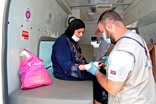 Medics working at a mobile clinic held jointly by Lebanese NGO Amel Association International and Medecins du Monde provide medical care on August 11 to the residents of Beirut's badly-damaged Karantina district following the earth-shaking explosion which killed more than 170 people and wounded more than 6,000 in the Lebanese capital on August 4 (AFP photo)