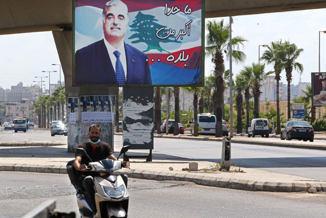 A man rides a motorbike past a billboard bearing a picture of slain Lebanese Prime Minister Rafik Hariri, on a street in his southern hometown city of Sidon (Saida), on Tuesday (AFP photo)