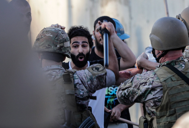Lebanese protesters scuffle with security forces during a demonstration against the lack of progress in a probe by authorities into a monster blast that ravaged swathes of the capital 40 days ago, near the presidential palace in Baabda, east of the capital Beirut, on Saturday (AFP photo)