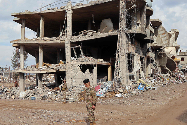 Lebanese soldiers stand next to a damaged building in the southern Lebanese village of Khiam on December 23, 2024, after the withdrawal of Israeli forces from the area under a ceasefire deal with Hezbollah (AFP photo))