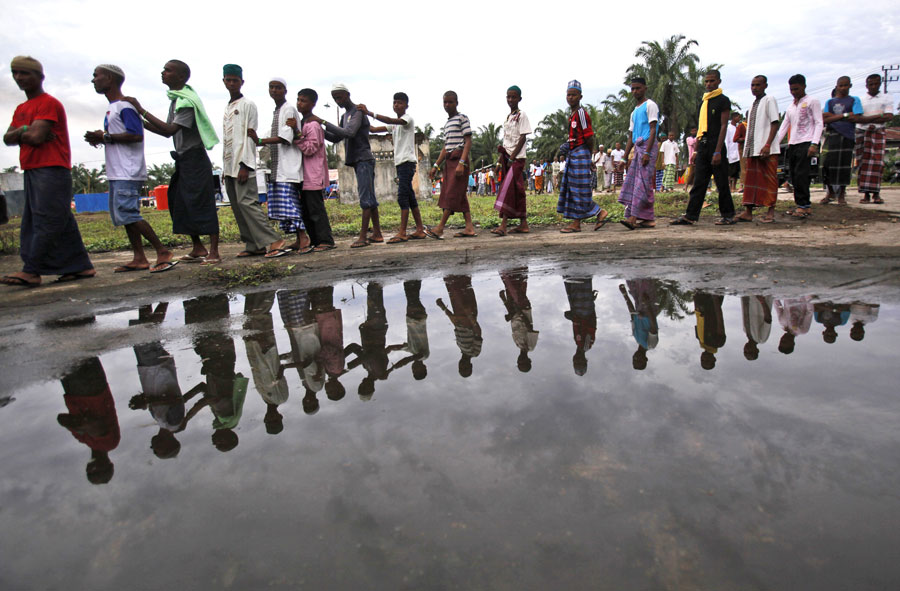 Rohingya migrants queue up for food at a temporary shelter in Bayeun, Aceh province, Indonesia, on Monday (AP photo)