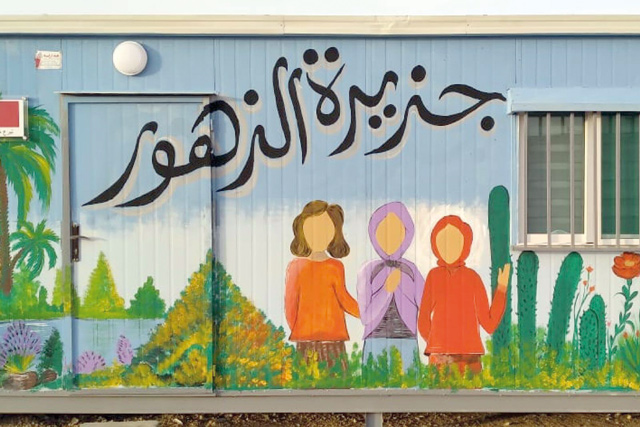Mercy Corps has established a new girls’ caravan in Azraq refugee camp. The Arabic writing on the mural reads: ‘Island of flowers’ (Photo courtesy of Mercy Corps website)