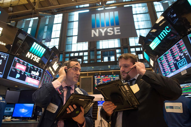 Traders work the floor at the closing bell of the Dow Jones at the New York Stock Exchange, in New York, on Monday (AFP photo)
