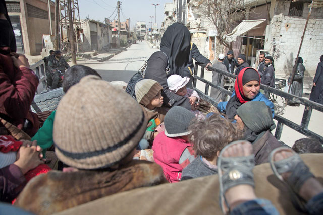 Syrians sit in the back of a truck ,driven by White Helmets, as they try to flee their homes in the town of Hamouria in Syria's besieged Eastern Ghouta region on Sunday, following reported air strikes. (AFP photo)