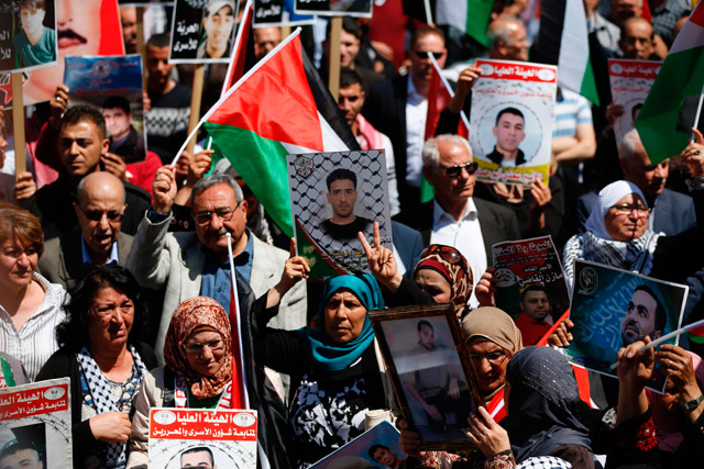 Protesters hold portraits of Palestinian prisoners during a rally in the West Bank city of Ramallah to show their support to Palestinians detained in Israeli jails after hundreds of them launched a hunger strike on Monday (AFP photo)