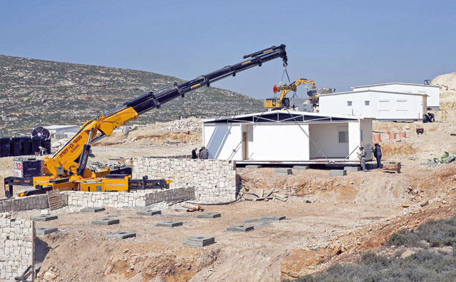 A construction crane installs new ‘mobile units’ in Amichai, the first new Israeli government-sanctioned settlement built in the Palestinian territories in some 25 years, near the settlement of Shiloh, on Wednesday (AFP photo)