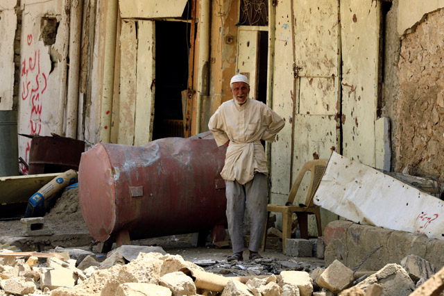 A civilian looks on from his home destroyed by clashes in the Old City of Mosul, Iraq, on Sunday (Reuters photo)