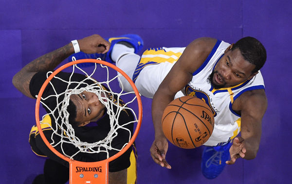 Golden State Warriors’ forward Kevin Durant (right) shoots as Los Angeles Lakers’ forward Thomas Robinson defends during their NBA basketball game on Friday in Los Angeles (AP photo by Mark J. Terrill)