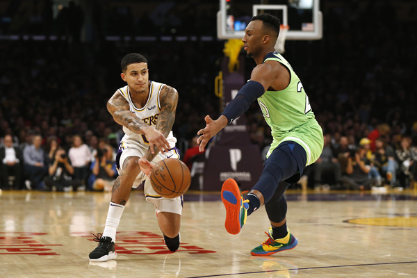 Kyle Kuzma of the Los Angeles Lakers passes around Josh Okogie of the Minnesota Timberwolves during their NBA game in Los Angeles, California, on Sunday  (AFP photo by Katharine Lotze)