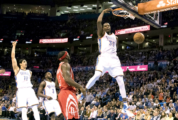 Kevin Durant of the Oklahoma City Thunder runs past Ty Lawson of the Houston Rockets to dunk during their third NBA game in Oklahoma City, on Friday (AFP photo by J Pat Carter)