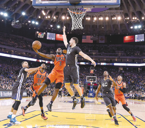 Klay Thompson of the Golden State Warriors leaps to challenge the shot of Dion Waiters of the Oklahoma City Thunder during their NBA game in Oakland, California, on Saturday  (AFP photo by Thearon W. Henderson)