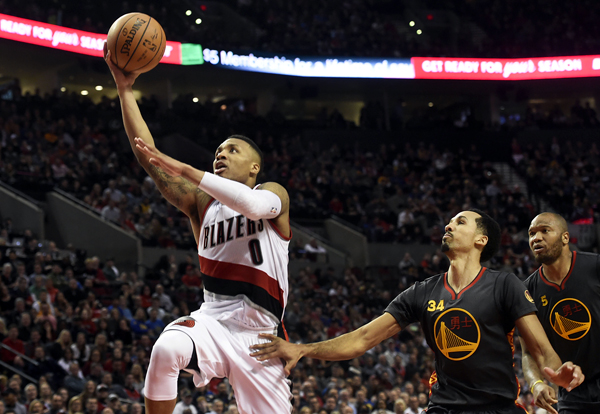 Portland Trail Blazers guard Damian Lillard drives to the basket as Golden State Warriors guard Shaun Livingston and centre Marreese Speights watch during their NBA game in Portland on Friday (Reuters photo by Steve Dykes)