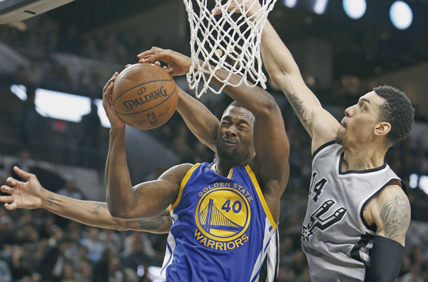 Harrison Barnes of the Golden States Warriors has his shot blocked by Kawhi Leonard of the San Antonio Spurs, not visible, and Danny Green of the San Antonio Spurs during their NBA game in San Antonio on Saturday (AFP photo by Ronald Cortes)