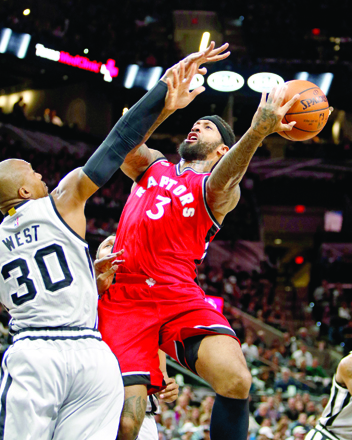 Toronto Raptors’ forward James Johnson is fouled by San Antonio Spurs’ forward David West during their NBA game in San Antonio on Saturday (AP photo by Michael Thomas)
