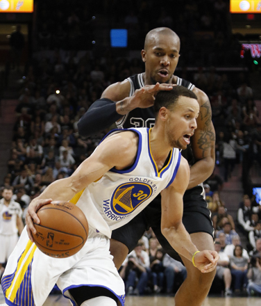 Stephen Curry of the Golden State Warriors drives in front of David West of the San Antonio Spurs during their NBA game in San Antonio, Texas, on Sunday (AFP photo by Ronald Cortes)