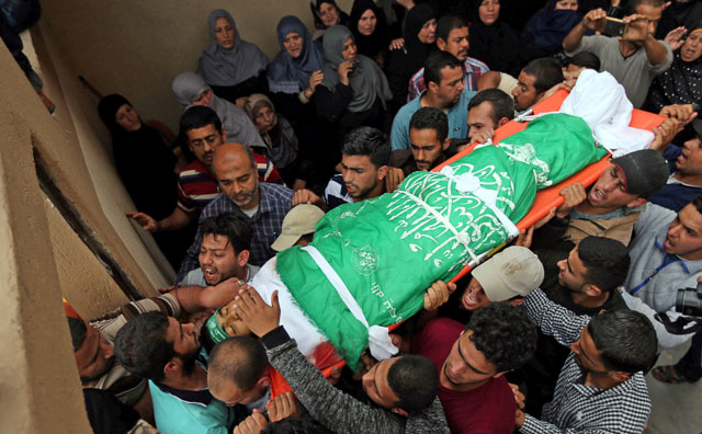 Mourners carry the body of a Palestinian, who was killed at the Israel-Gaza border by Israeli occupation forces, during his funeral in Khan Younis in the southern Gaza Strip on Sunday (Reuters photo)