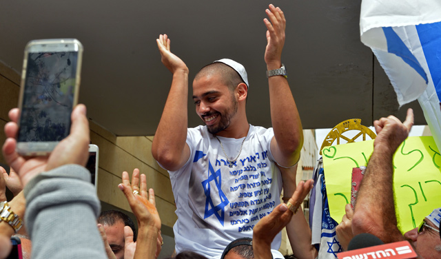 Israeli occupation soldier Elor Azaria, convicter of manslaughter for shooting dead a Palestinian, is lifted by friends near his family home in Ramla, near Tel Aviv, as they celebrate his release from prison earlier in the morning, on Tuesday (AFP photo)