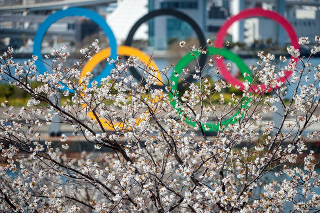 The Olympic rings are seen through cherry blossoms in Tokyo's Odaiba district on March 25 (AFP photo by Behrouz Mehri)