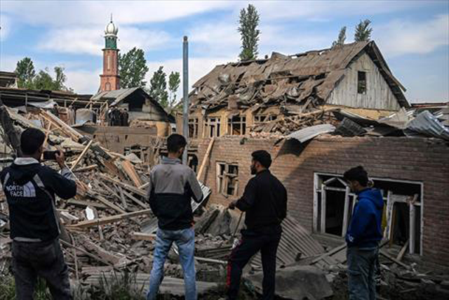 Neighbours gather near a demolished house related to the family of Ahsan Ul Haq Sheikh, who is suspected of involvement in the Pahalgam tourist attack, in Murran village of Pulwama, south of Srinagar, on April 26, 2025 (AFP photo)