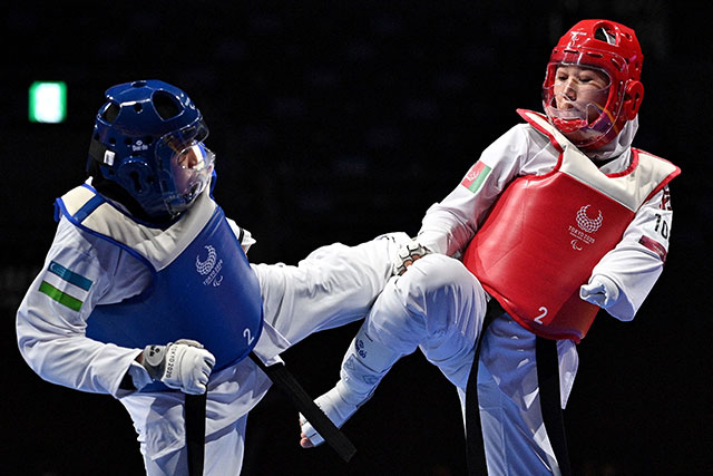Afghanistan's Zakia Khudadadi (right) competes with Uzbekistan's Ziyodakhon Isakova in their women's taekwondo K44 match during the 2020 Tokyo Paralympic Games in Chiba on Thursday (AFP photo by Philip Fong)