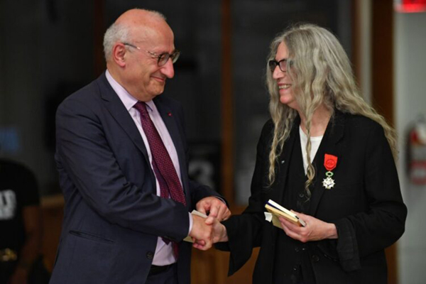 French Ambassador to the US Philippe Etienne and US singer-songwriter Patti Smith shake hands after she received the merit ‘Legion d’Honneur’ in New York, on Saturday  (AFP photo by Andrea Renault)