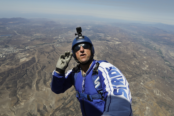 In this July 25 photo, skydiver Luke Aikins signals to pilot Aaron Fitzgerald as he prepares to jump from a helicopter in Simi Valley, California (AP photo by Jae C. Hong)
