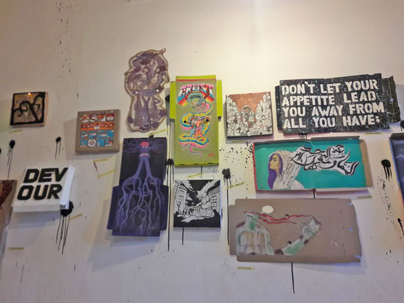 The walls of F.A.D.A 317 are covered with pizza boxes used as canvases for the work of local artists (Photo by Camille Dupire)