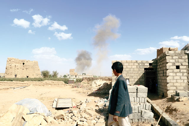 A boy looks at dust raising from the site of air strikes in Saada, Yemen, on Tuesday (Reuters photo)
