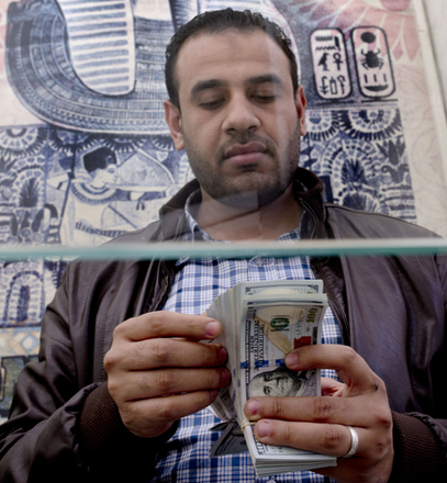A man counts US dollars at an exchange office in Cairo, on Monday (AP photo)