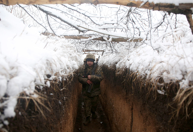 Ukrainian servicemen walk in a trench on their position on the front line with Russia-backed separatists near the small town of Svitlodarsk, in Donetsk region, on Saturday (AFP photo)