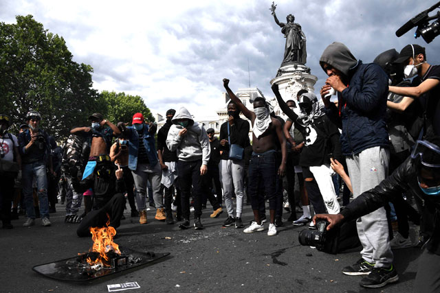 Protesters burn a police shield during a rally as part of the 'Black Lives Matter' worldwide protests against racism and police brutality, on Place de la Republique in Paris, on Saturday (AFP photo)