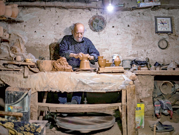 Syrian-Armenian potter Misak Antranik Petros uses an ancient pottery wheel to churn different types of pots at his workshop located inside an ancient mud-brick house near the city of Qamishli in Syria’s north-eastern Hasakeh province, on Saturday (AFP photo)