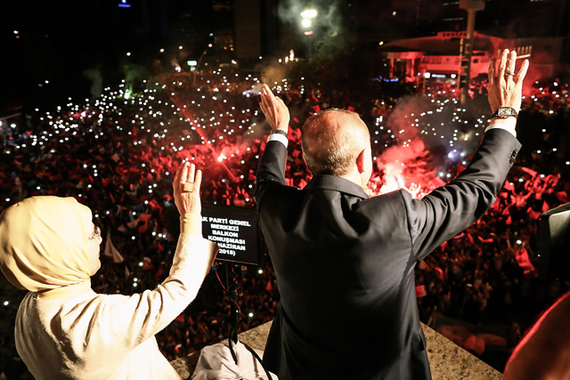 This handout photo released on Monday shows Turkish President Recep Tayyip Erdogan and his wife Emine Erdogan waving to supporters gathered above a balcony at the headquarters of the AK Party in Ankara, on Sunday, as they celebrate Erdogan winning five more years in office with sweeping new powers after a decisive election victory (AFP photo)