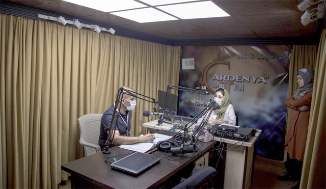 A lawyer chats with his hostess during a talk show at the Gardenya FM radio station studio at the Arbat refugee camp, 20km east of Sulaimaniyah, Iraq’s autonomous Kurdistan region’s second-biggest city, on November 3 (AFP photo)