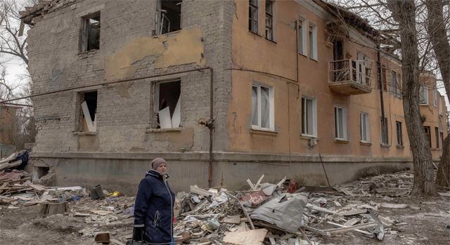 A woman walks past a residential building destroyed by shelling in Kostyantynivka, in the eastern Donetsk region, on Friday (AFP photo)