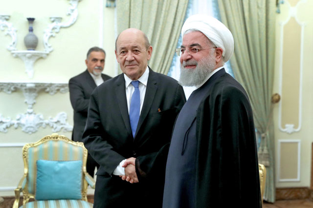 Iranian President Hassan Rouhani shakes hands with French Foreign Affairs Minister Jean-Yves Le Drian during their meeting in Tehran, Iran, on Monday (Reuters photo)
