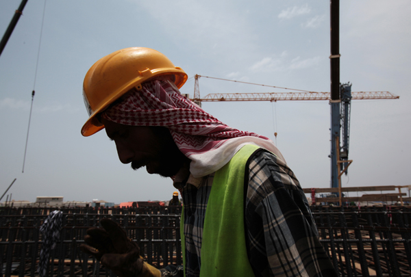 In this file photo, a man works at a construction site in Jeddah, Saudi Arabia. Saudi Arabia's credit rating has been downgraded by Moody's because of the long and deep slump in oil prices. Moody's Investors Service said Saturday that it also downgraded Gulf oil producers Bahrain and Oman (AP photo)
