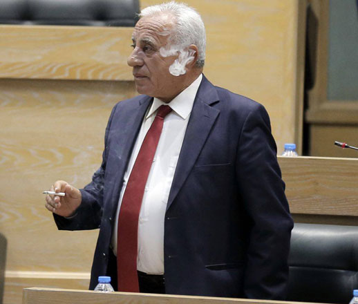 A lawmaker smokes as he attends Sunday’s House meeting (Photo by Osama Aqarbeh)
