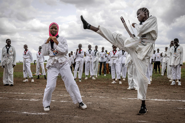 Ajok Chol, 18, a South Sudanese refugee (L), performs a taekwondo kick during a sparring demonstration with another refugee girl as part of a showcase performance at a sports day event at the Kalobeyei Sports Complex in Kalobeyei on March 28, 2025 (AFP photo) 